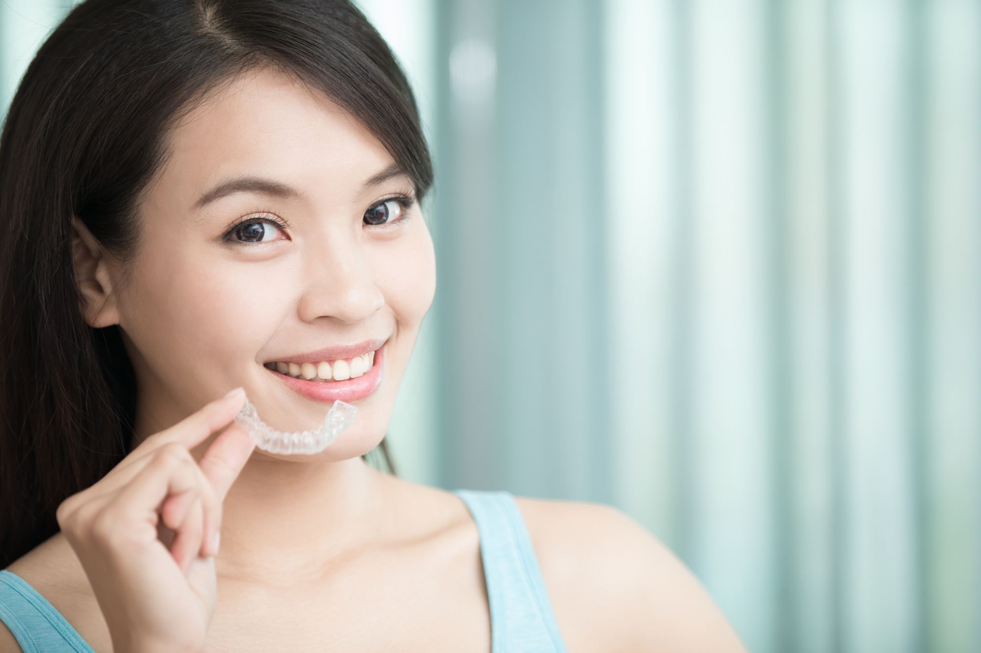 woman holding her clear aligners